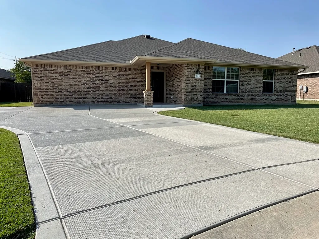 Newly poured concrete driveway at a home in Pearland, Texas with a broom finish