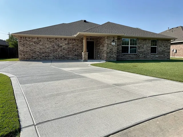 Newly poured broom-finish concrete driveway at a Pearland, Texas home